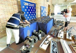 Un agente muestra las armas que el joven detenido la pasada semana en Málaga vendía a través de anuncios publicados en internet.