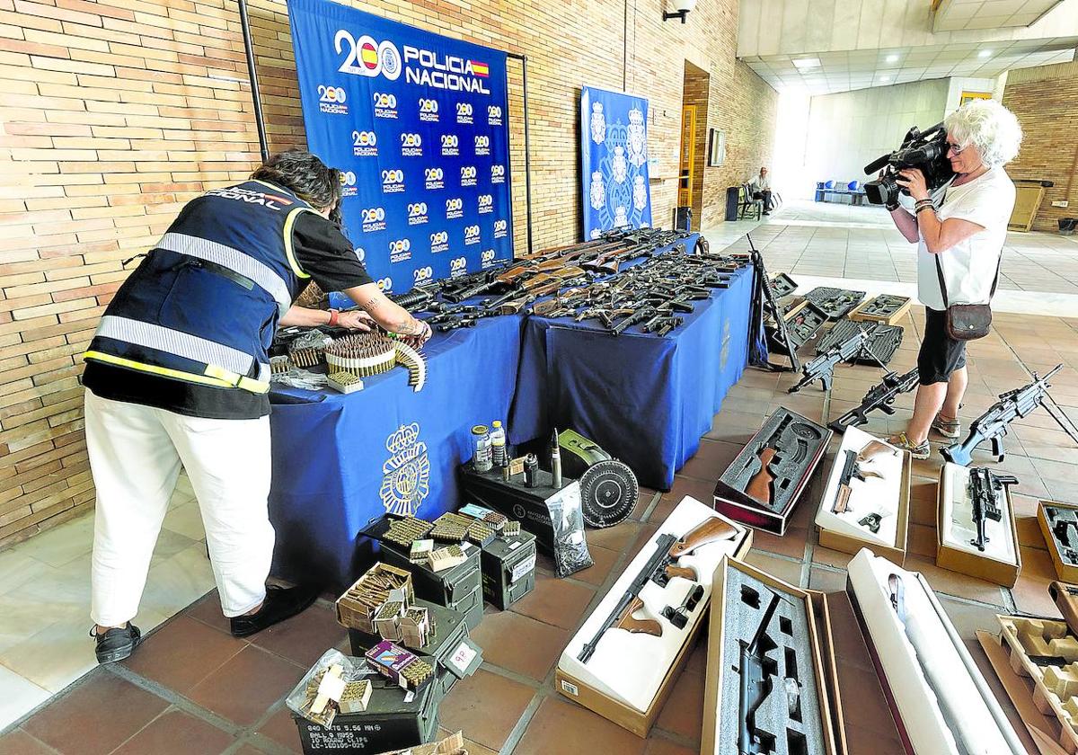 Un agente muestra las armas que el joven detenido la pasada semana en Málaga vendía a través de anuncios publicados en internet.