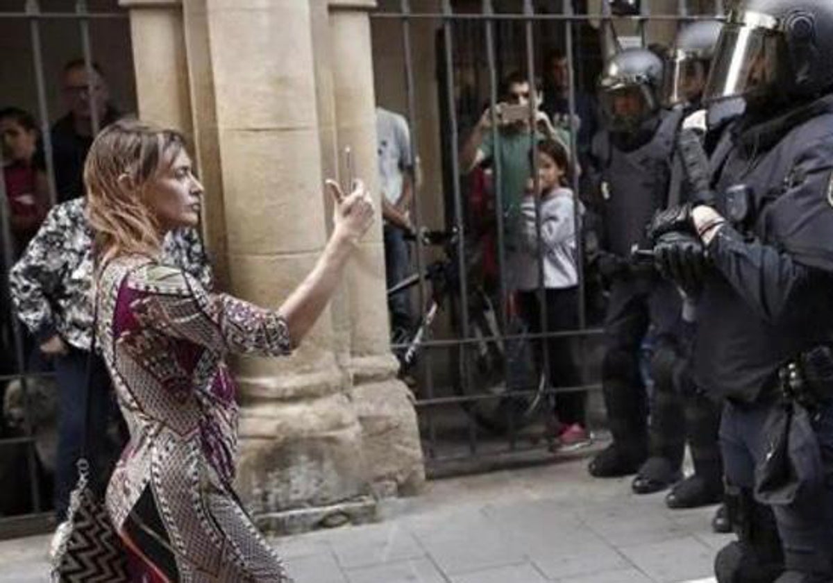 Una mujer fotografía a los antidisturbios de la Policía Nacional en Pamplona