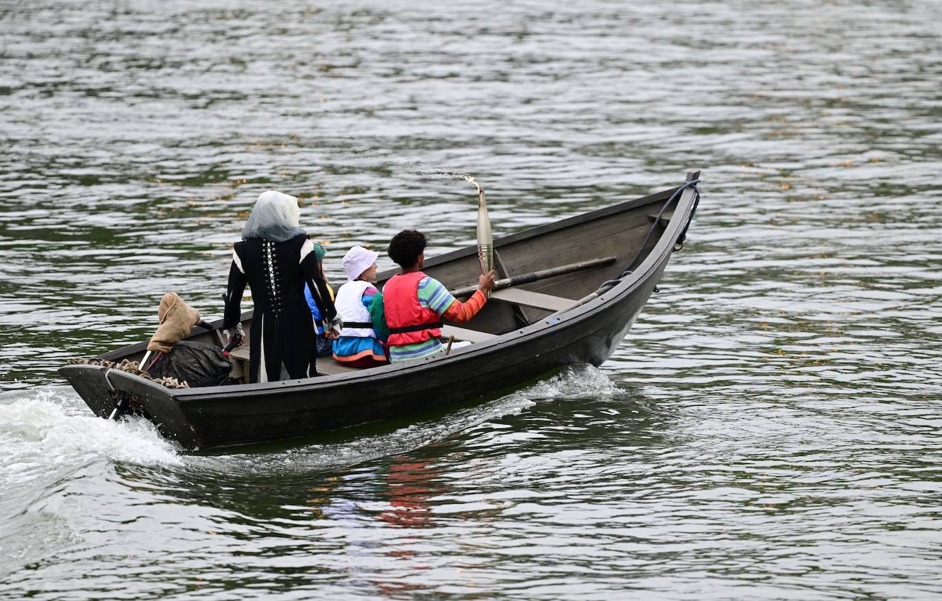 El barco que porta la antorcha olímpica aparece en el Sena.