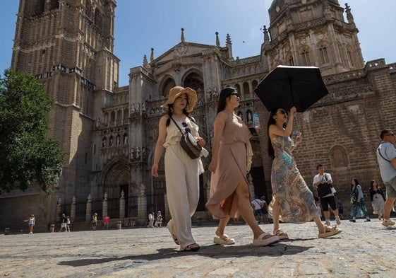 Varios turistas caminan por los alrededores de la catedral de Toledo pese al intenso calor.