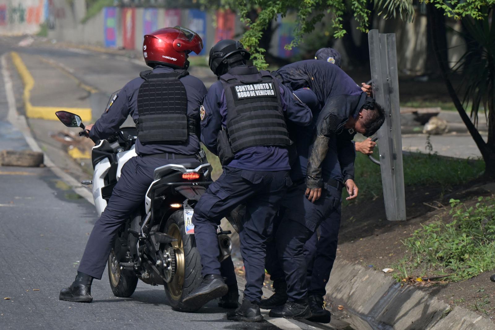 La Policía se lleva a un agente herido en los disturbios.