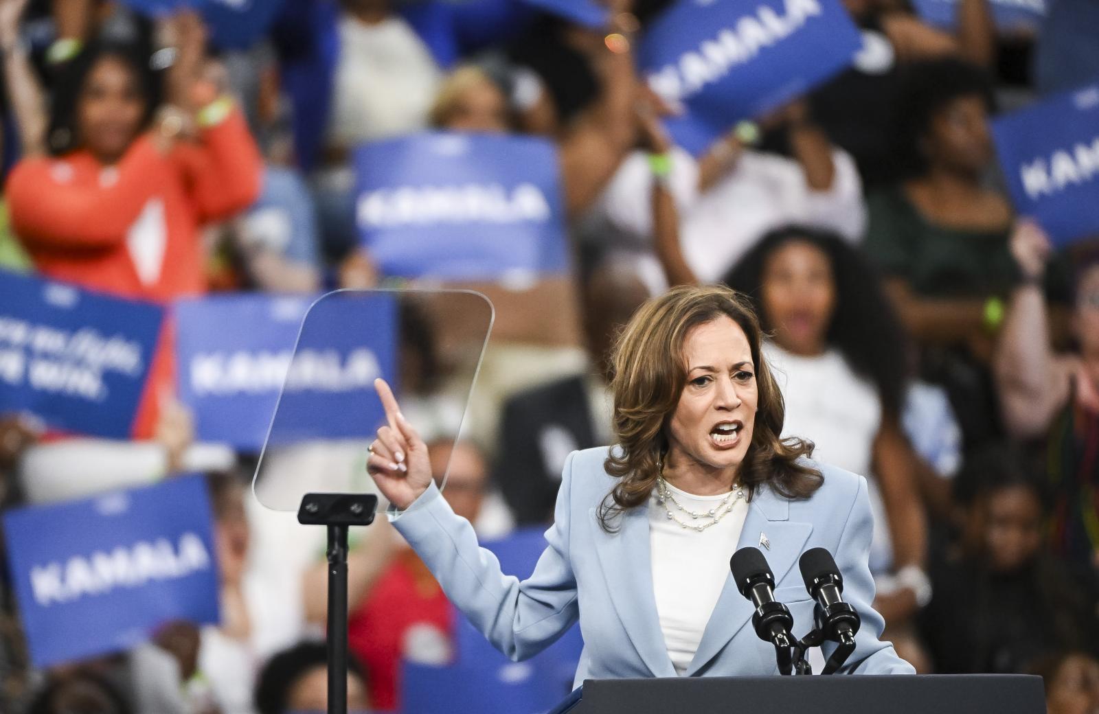 Kamala Harris, Atlanta'daki mitingi sırasında kendini onaylayan bir jest yapıyor.