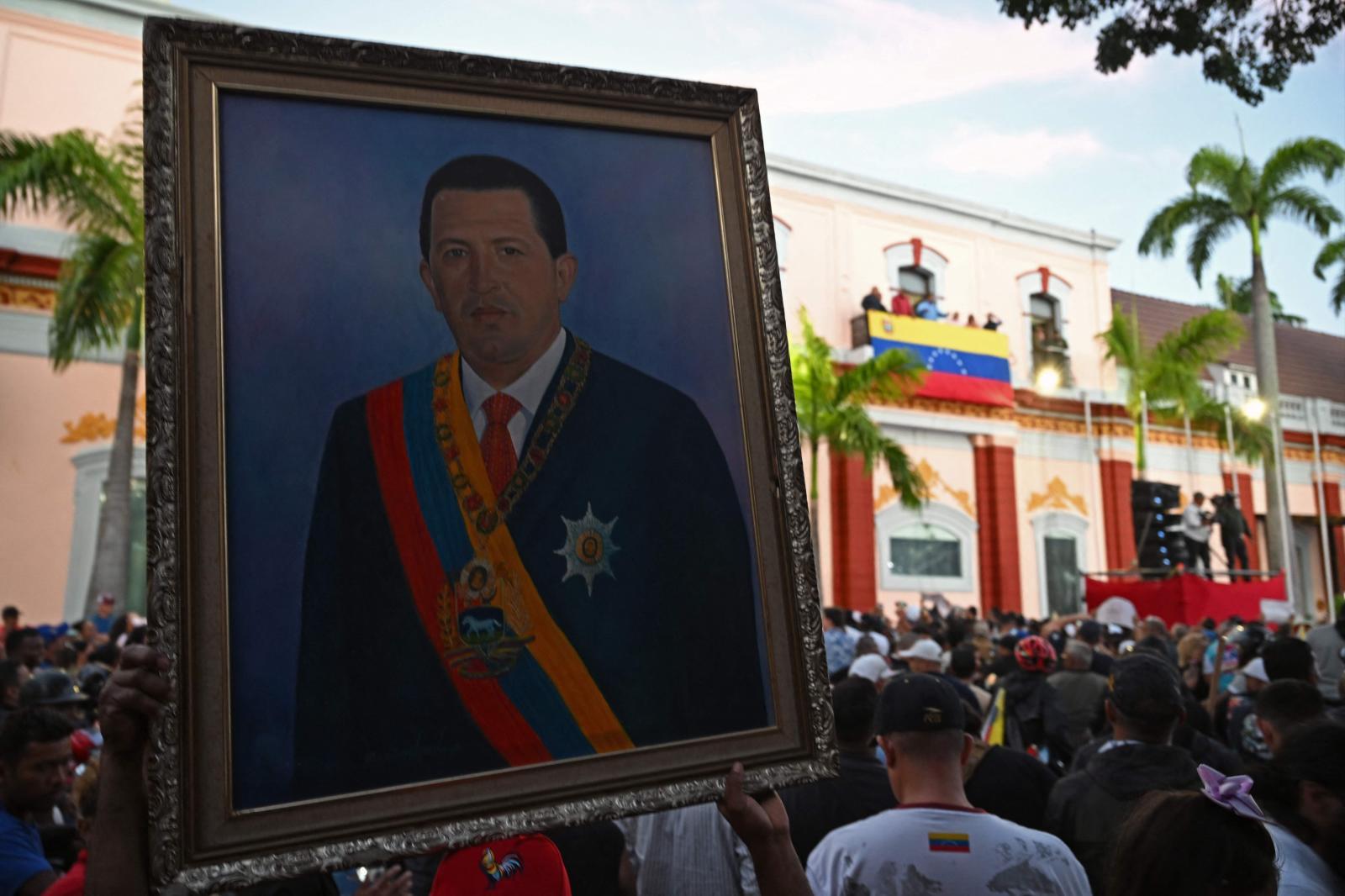 Manifestantes acuden con un retrato de Hugo Chávez a jalear a Maduro delante del Palacio de Miraflores.