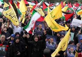 Iraníes sostienen una imagen de Ismail Haniyeh y banderas palestinas y de Hezbolá durante una protesta en Teherán.