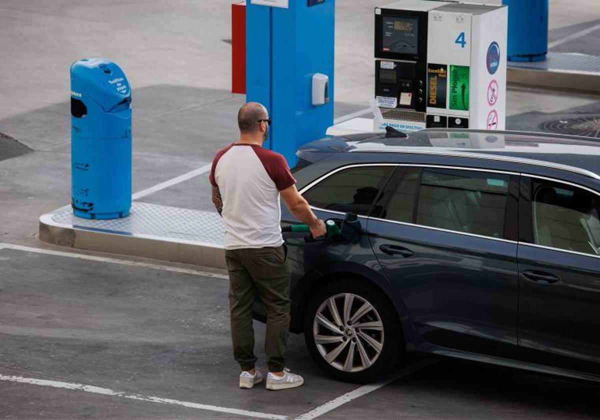 Un conductor llena el depósito de su coche en una gasolinera.