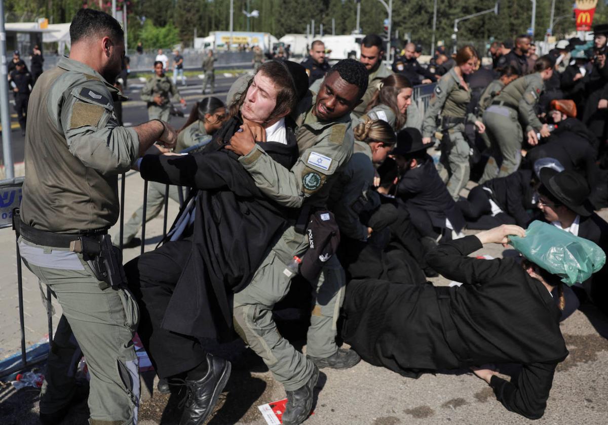 Dos policías tratan de reducir a un ultraortodoxo en medio del tumulto formado delante de la base militar de Tel Hashomer, en el centro de Israel.