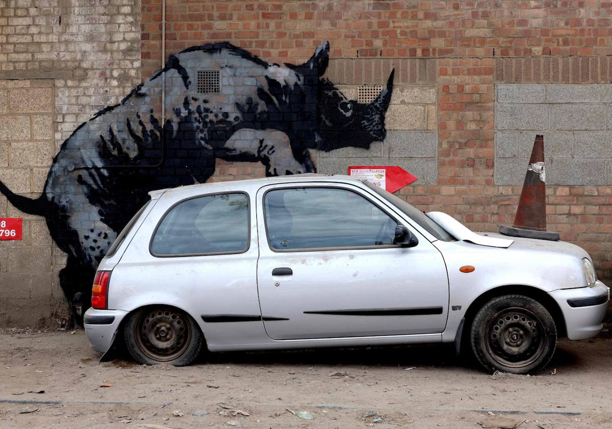 El rinoceronte que cubre un coche apareció este lunes en el barrio Charlton. Es el octavo 'zoografiti' del enigmático grafitero en una semana.