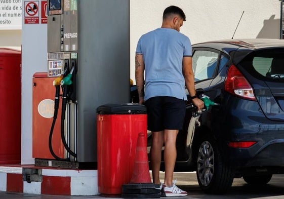 Un hombre reposta en una estación de servicio.