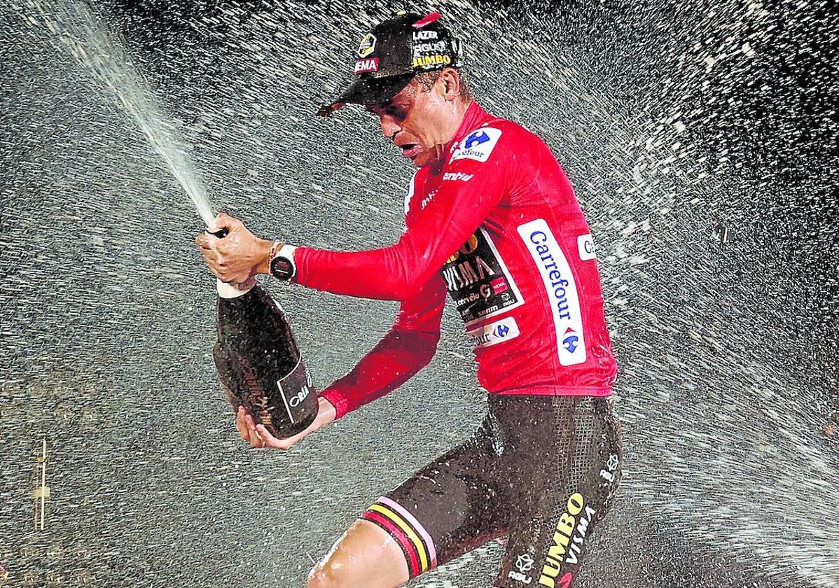 Sepp Kuss descorcha la botella de cava en el podio como campeón de la Vuelta 2023.