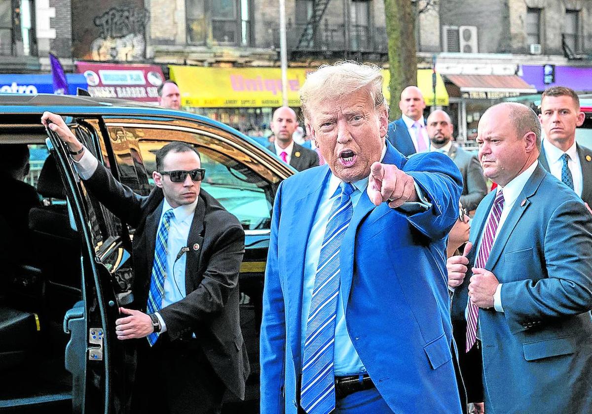 Trump se dirige al grupo de trabajadores de una bodega durante una visita a Harlem.