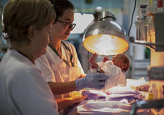 Dos sanitarias, con un recién nacido.