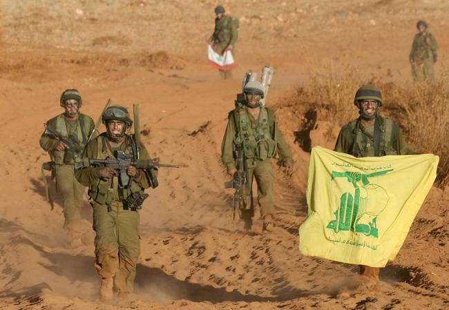 Tropas israelíes muestra una bandera de Hezbolá capturada en 2006.