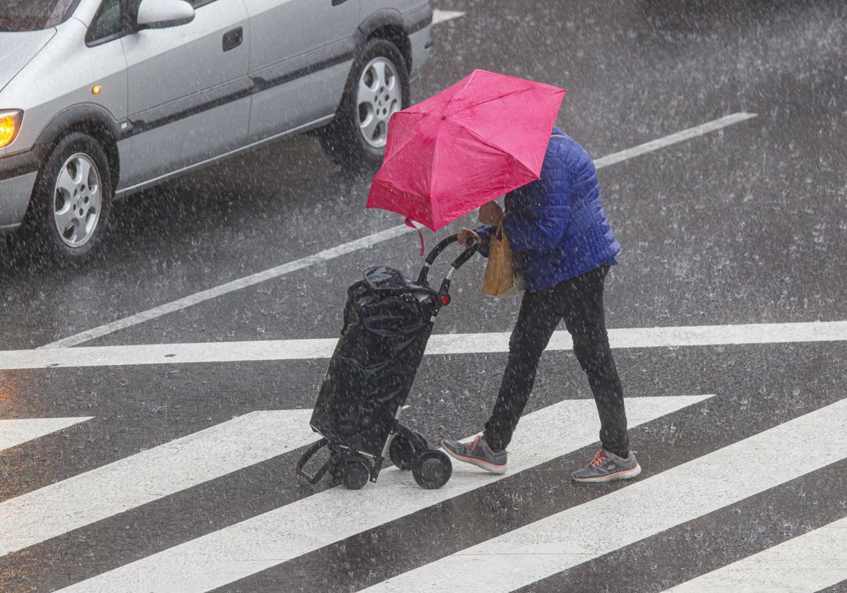 Un hombre se protege de la lluvia en Zaragoza el 21 de septiembre.