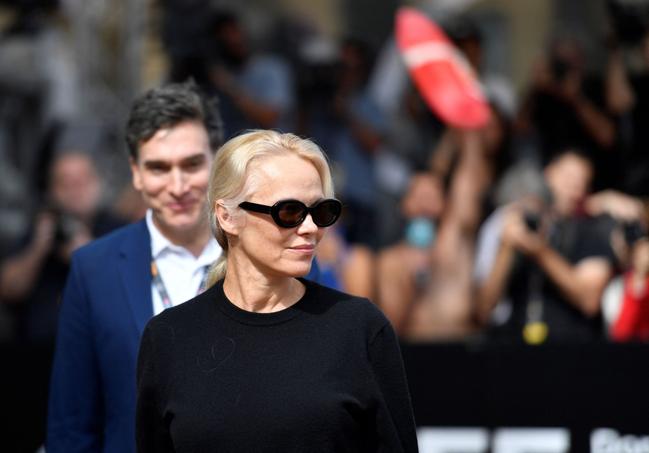 Pamela Anderson a su llegada a San Sebastián. Al fondom, un 'vigilante de la playa'.