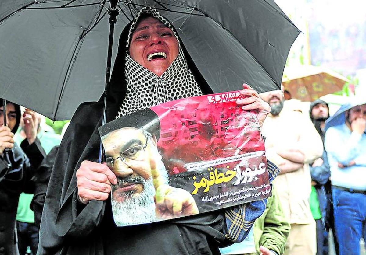 Una mujer llora mientras porta una imagen de Nasrala durante unas de las manifestaciones de protesta por el asesinato del líder de la milicia chií.