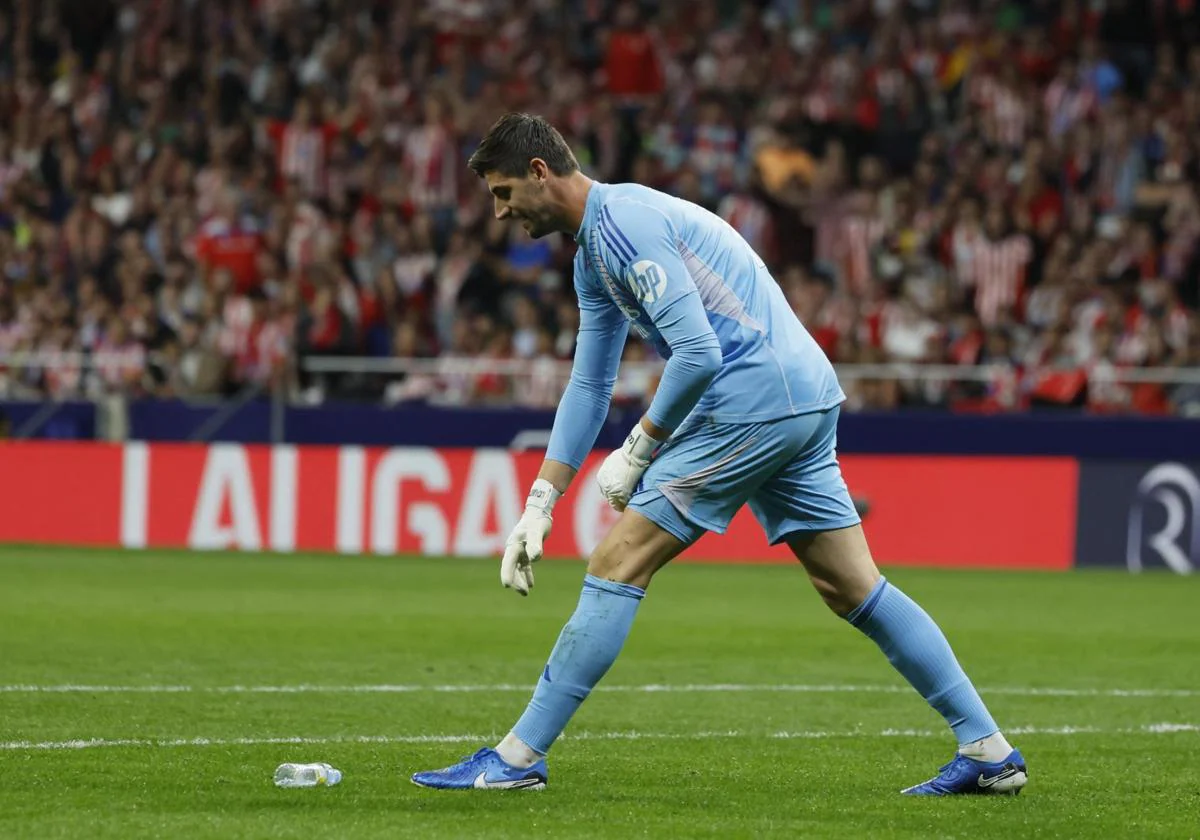 Thibaut Courtois recoge uno de los objetos que le lanzaron durante el derbi del domingo en el Metropolitano.