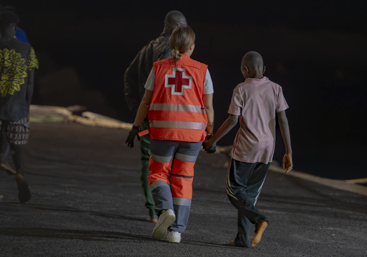 Un trabajador de la Cruz Roja atiende a uno de los migrantes que ha llegado a El Hierro