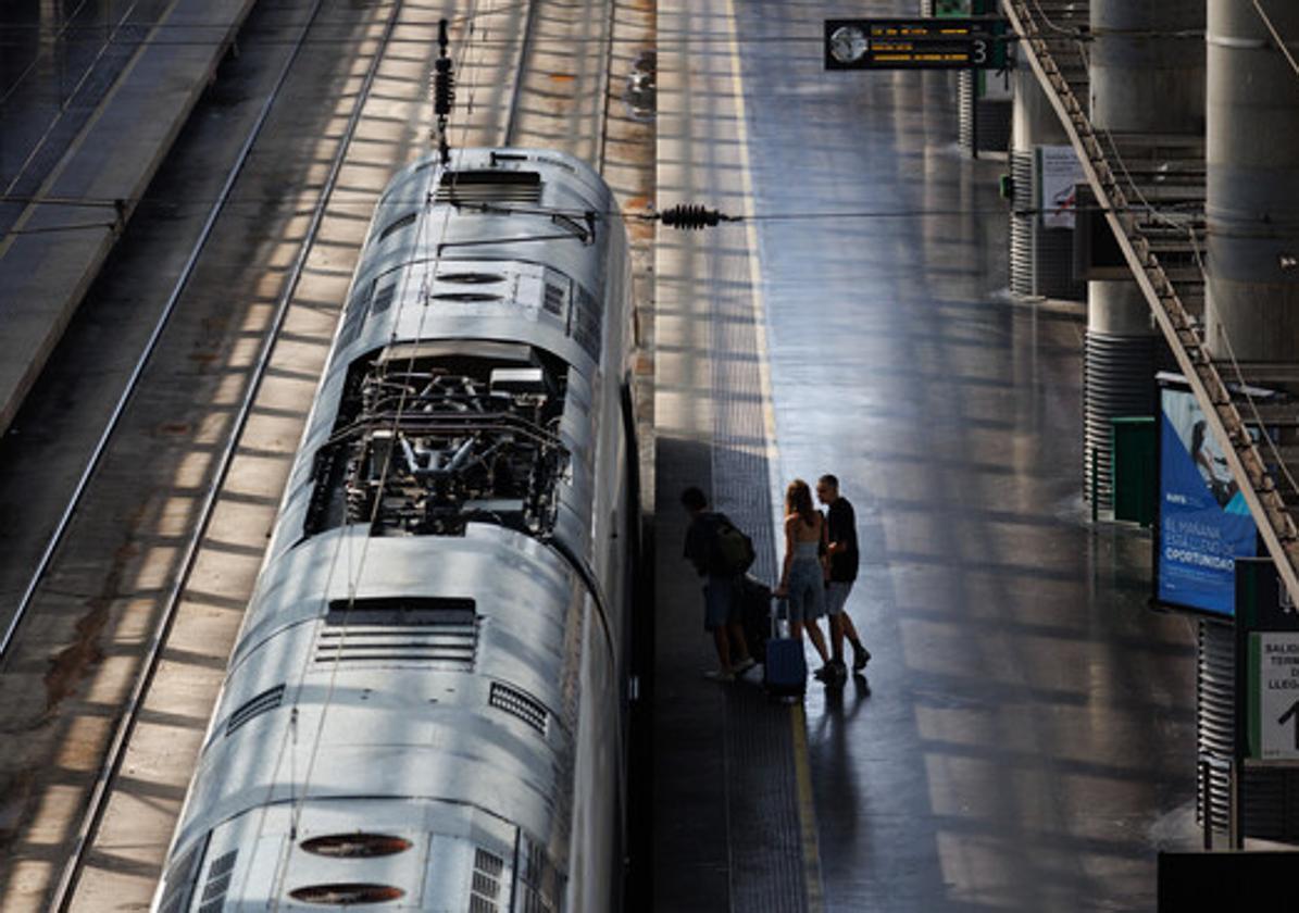 Dos pasajeros subiendo a un tren en Atocha.