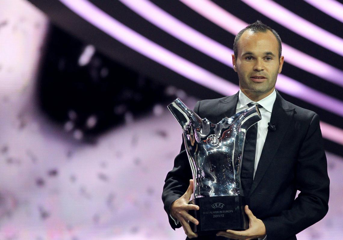 Iniesta, posa con el trofeo que le acredita como el mejor futbolista de Europa 2011-2012