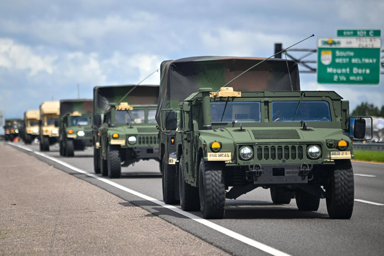 A military convoy is deployed and, below, sandbags to protect the businesses.