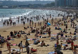 La playa de Gijón, llena de turistas.