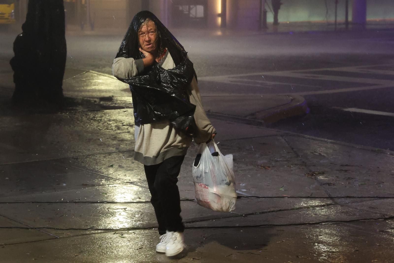 Una mujer camina por el centro de la ciudad mientras el huracán Milton toca tierra el 9 de octubre de 2024 en Tampa, Florida.