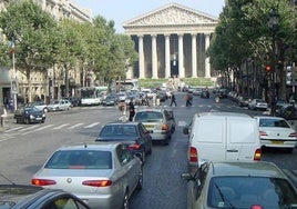 Vehículos transitan por una avenida de París.