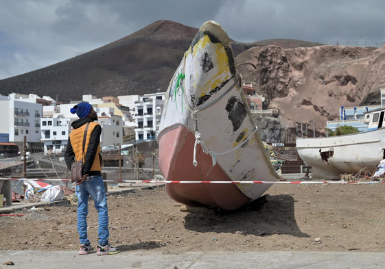 Un migrante observa una embarcación llegada a El Hierro