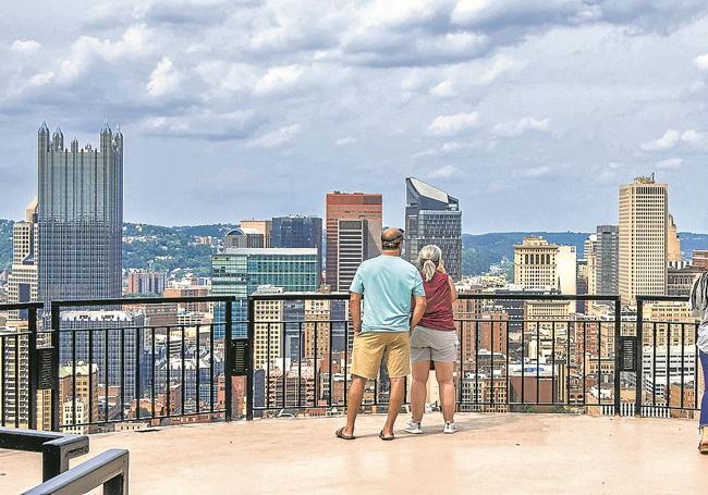 Cuatro personas observan la ciudad de Pittsburgh desde el mirador de Mount Washington.