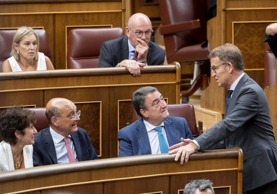 Alberto Núnez Feijóo (derecha) se dirige a la bancada del PNV, con Aitor Esteban al frente, al término del discurso de su investidura fallida hace un año.