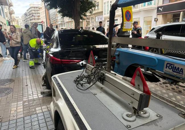 Momento en que una grúa engancha el BMW para liberar el acceso a la estación de Colón.