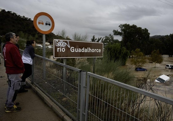 Vecinos de Álora observan la crecida del río Guadalhorce.