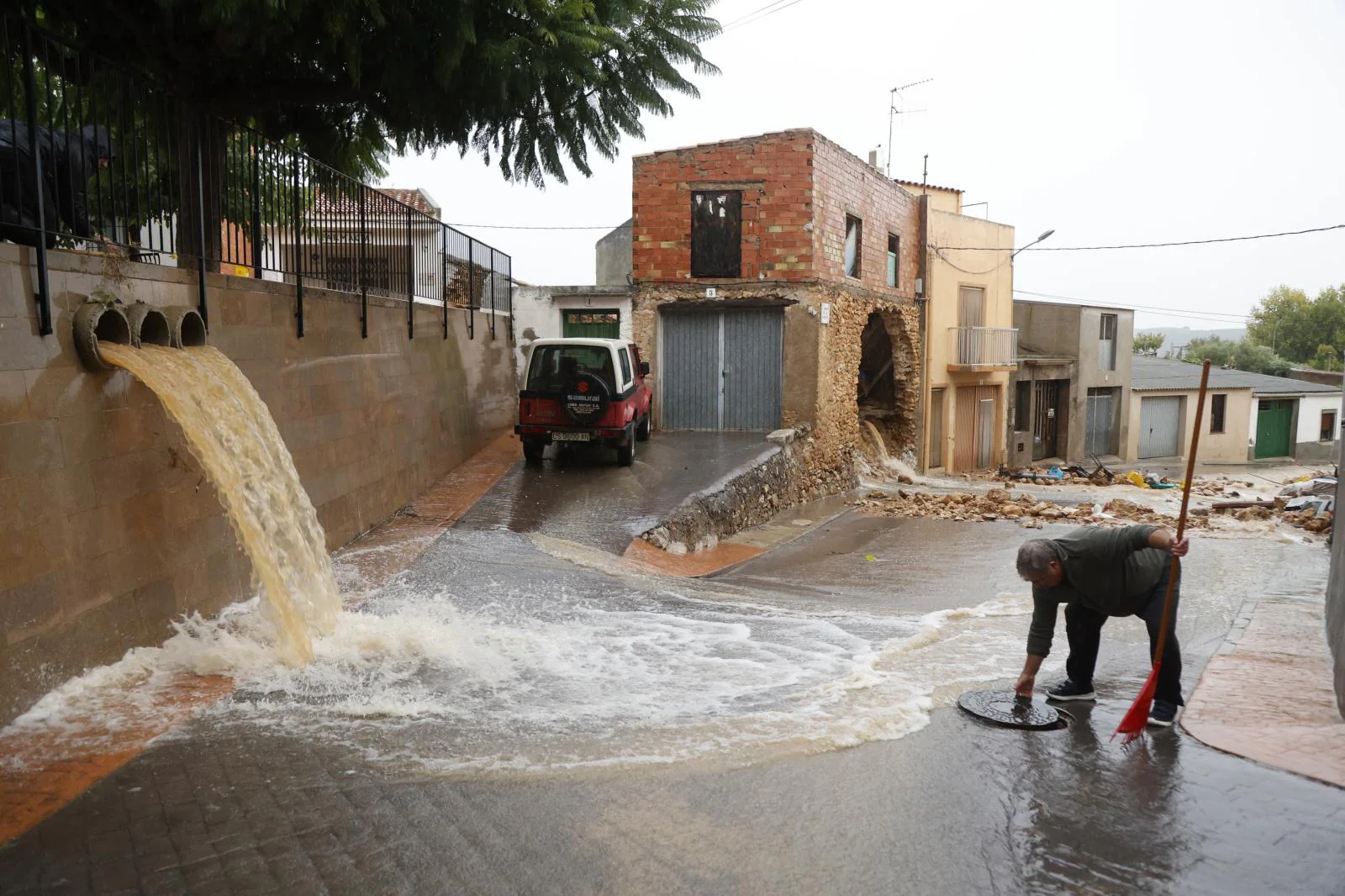 Un vecino de la provincia de Castellón trata de achicar agua en una de las calles de su municipio.