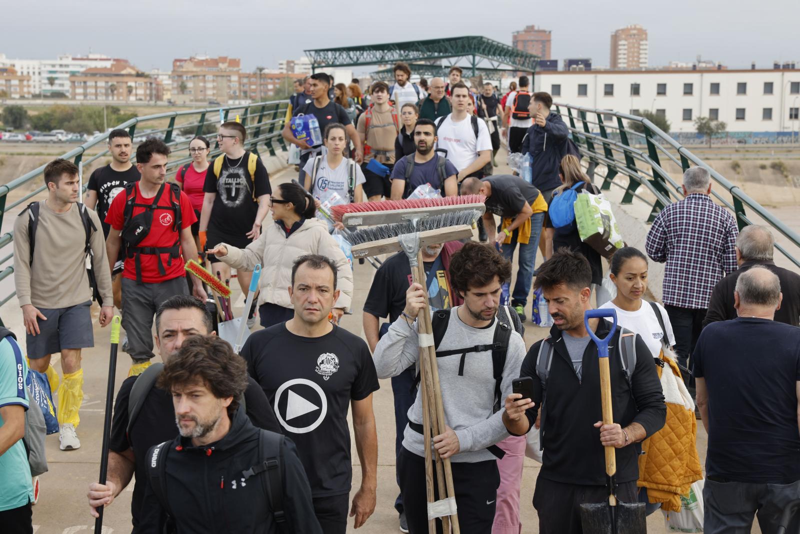 Cientos de ciudadanos con herramientas, alimentos y enseres recorren los barrios del sur de Valencia para tratar de ayudar a los damnificados