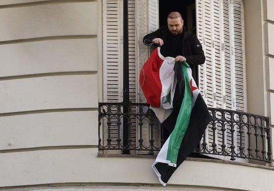 Una persona coloca la bandera insurgente en la embajada de Siria en Madrid.