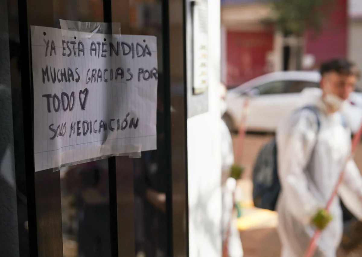 Imagen secundaria 1 - Lola, junto a Ana, una de las voluntarias que ha acudido en su ayuda tras conocer la situación de la sexageneria. El nuevo cartel colocado en el portal de su domicilio, y Lola, emocionada, atiende una llamada en su piso de Catarroja.