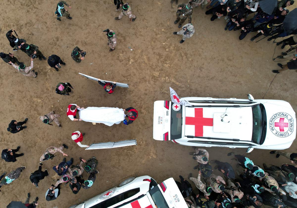 Vista aérea que muestra a miembros de la Cruz Roja recibiendo un ataúd mientras militantes de Hamas entregan a los rehenes fallecidos Oded Lifschitz, Shiri Bibas y sus dos hijos Kfir y Ariel Bibas.