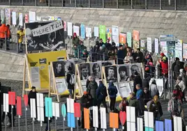 Viandantes observan fotos históricas en el antiguo recorrido del Muro de Berlín.