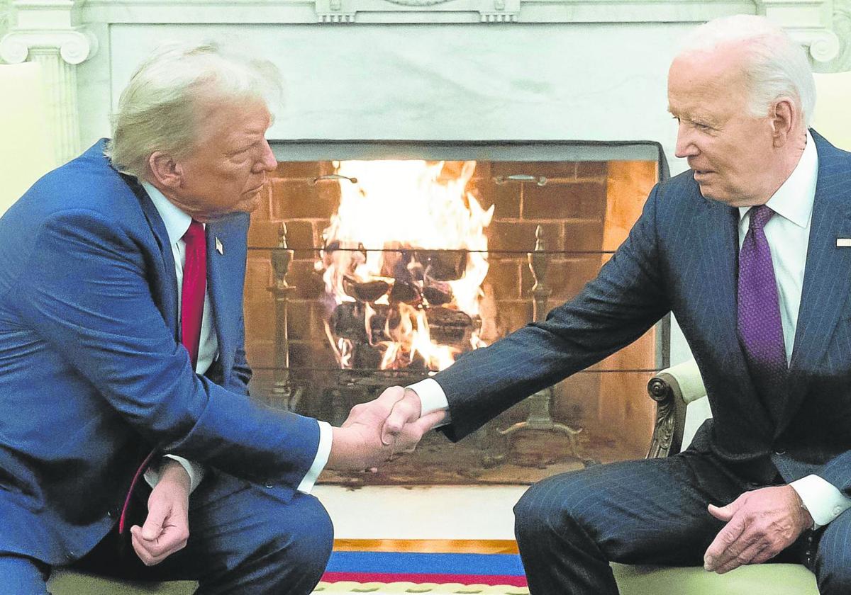 Trump y Biden se estrechan la mano ante la chimenea del Despacho Oval de la Casa Blanca.