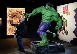 Un visitante se hace un selfi junto a una figura a tamaño real del Increíble Hulk.