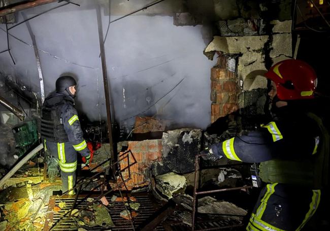 Bomberos trabajan en un edificio dañado durante los ataques con misiles y drones rusos.