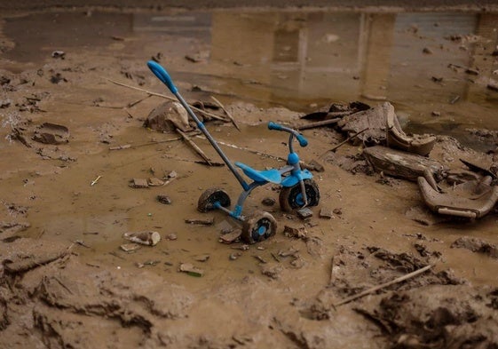 El triciclo de un niño, abandonado sobre el barro en Paiporta.