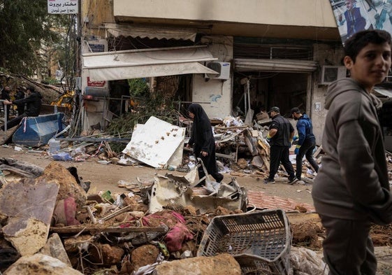 Una mujer pasa junto a un edificio dañado tras un ataque israelí en la zona de Zuqaq al-Blat, en Beirut.