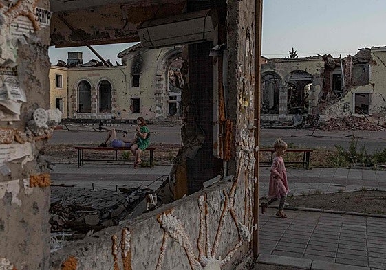 Una niña juega junto a unos edificios residenciales destruidos por bombardeos rusos en Donetsk.