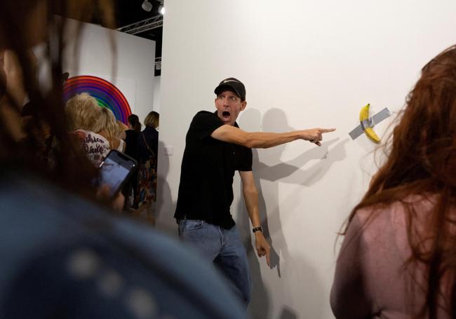 Un hombre posa con la obra 'Comedian'.