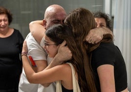 Uno de los rehenes liberados durante la tregua se abraza a sus familiares.