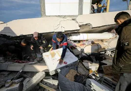 Civiles revisan los daños producidos en una escuela convertida en un centro de refugiados tras los ataques de este miércoles.