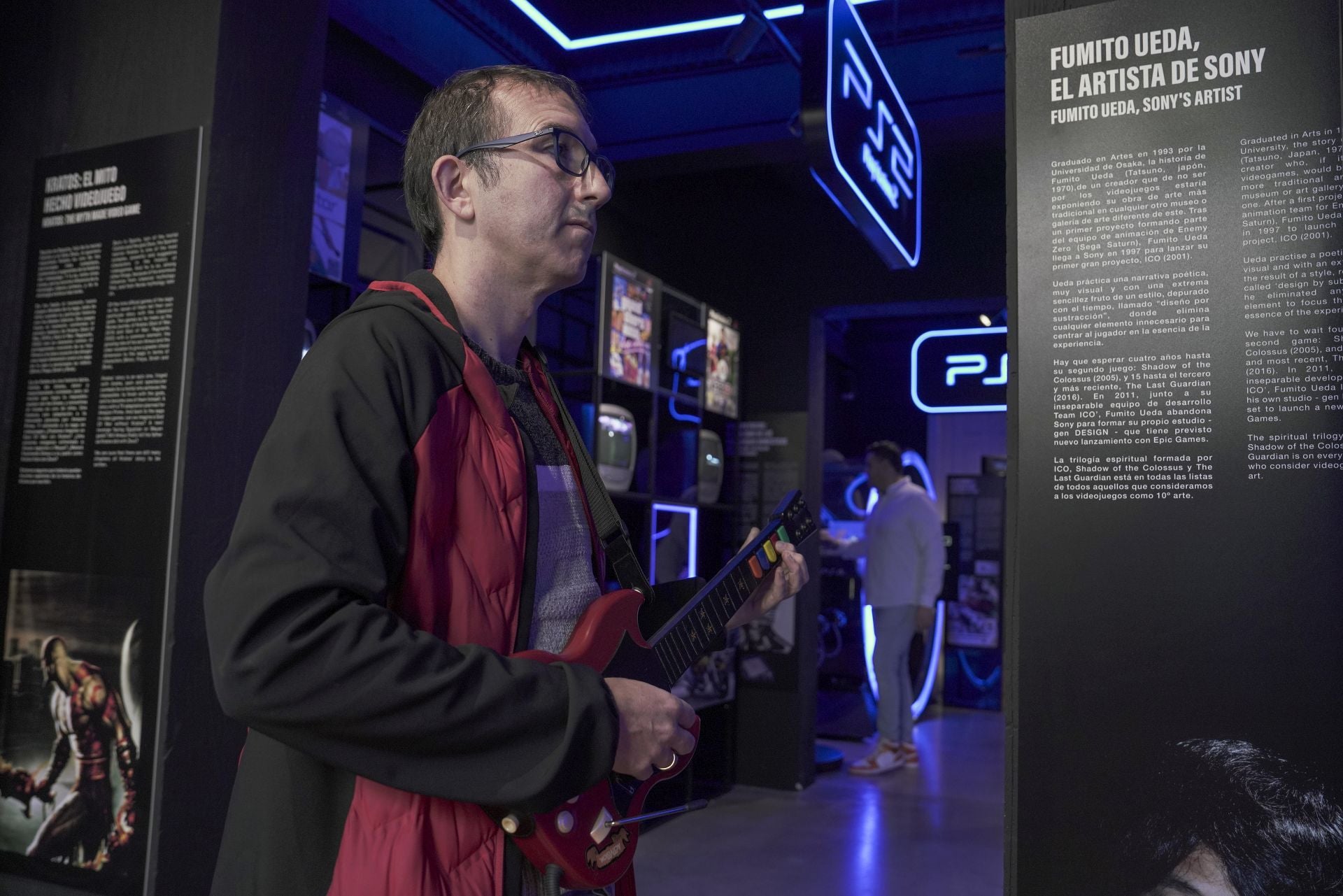 Un visitante del museo sostiene la guitarra que pertenece a uno de los juegos que se pueden probar