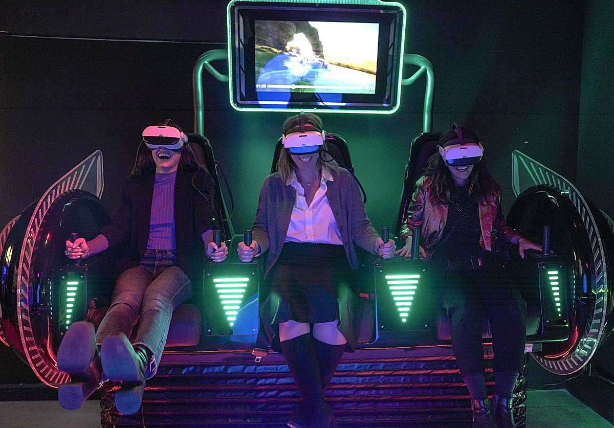 Three women enjoy one of the virtual reality experiences at OXO, the Video Game Museum in Madrid.